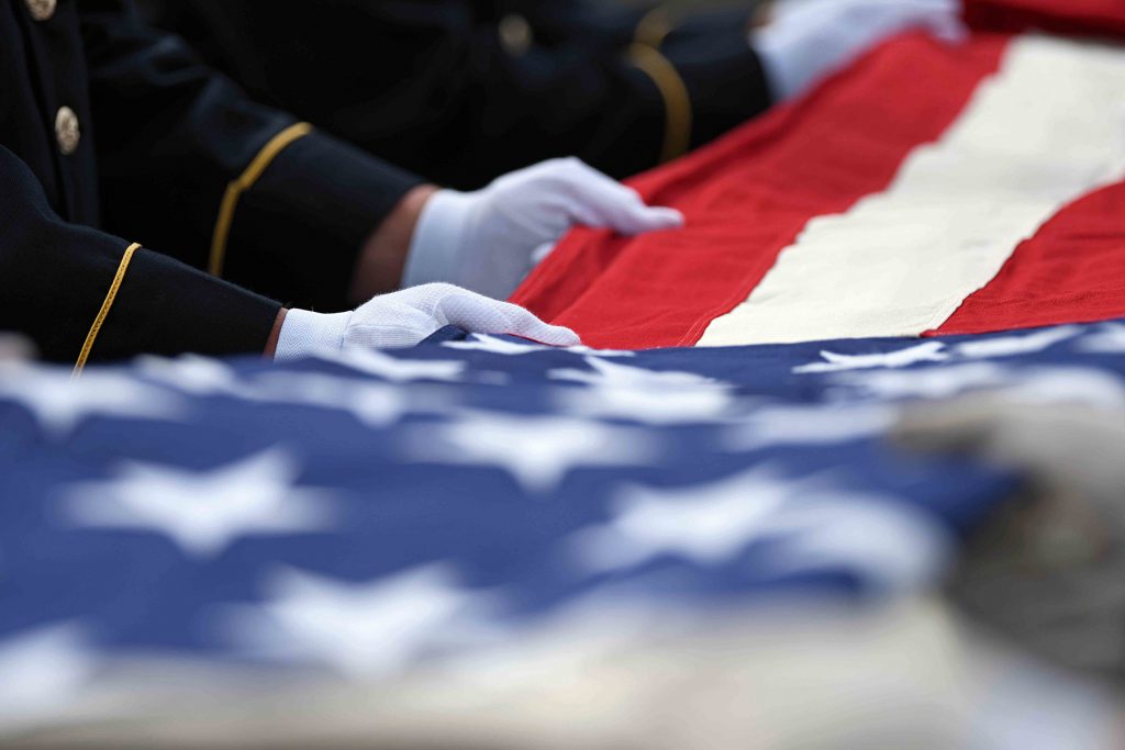 Hands folding American Flag