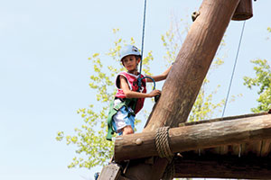 boy climbing at camp corral