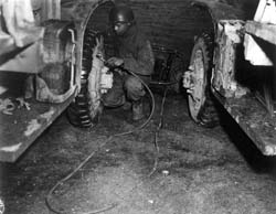 A truck driver fills a tire with air along the Red Ball Express highway during World War II. Photo courtesy Army Transportation Museum.