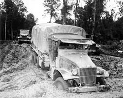 African American members of the World War II Red Ball Express repair a 2.5-ton truck while a crewman at a machine gun keeps watch for the enemy. Photo courtesy Army Transportation Museum.