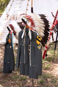 Eagle-feather war bonnets adorn U.S. military uniform jackets at a Ton-Kon-Gah (Black Leggings Society) ceremonial, held annually near Anadarko, Okla., to honor Kiowa tribal veterans. (Courtesy of the National Museum of the American Indian)